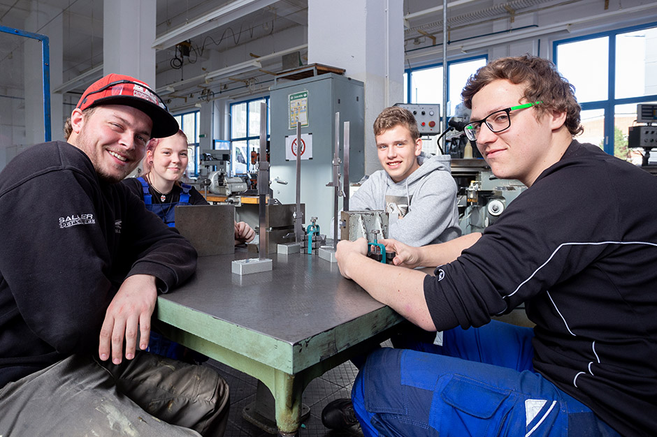 Vier junge Auszubildende an einem Tisch