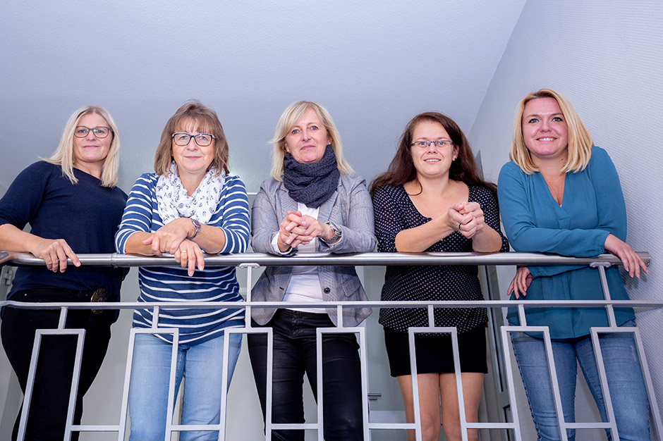 Fünf Damen posieren an einem Geländer