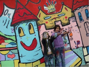 Zwei Kinder vor einer Graffiti-Wand