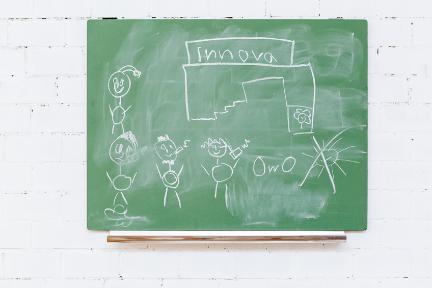 Eine Tafel mit Strichmenschen; In der Mitte steht das Wort "Innovation"