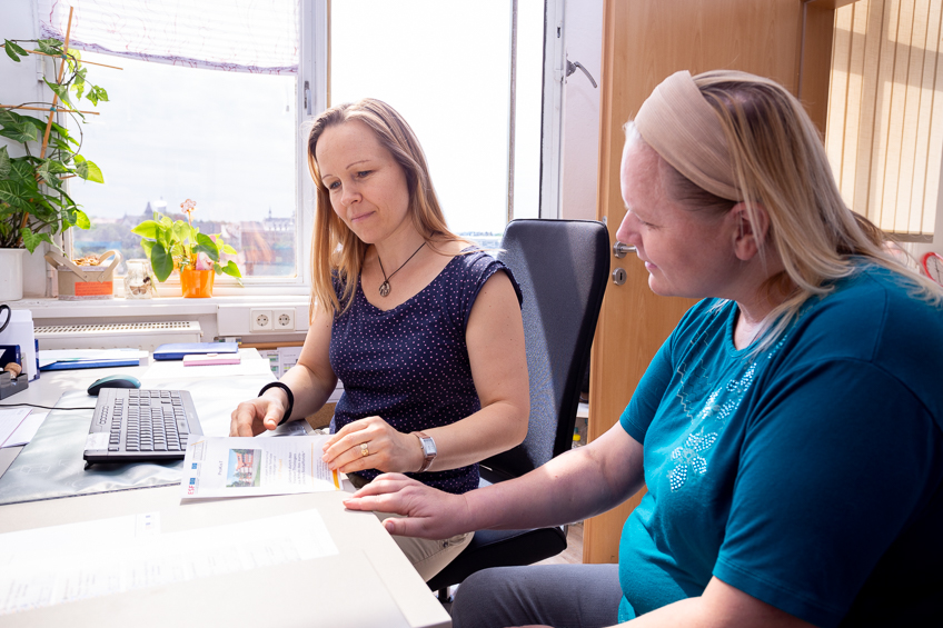 Zwei Frauen im Austausch an einem Bürotisch