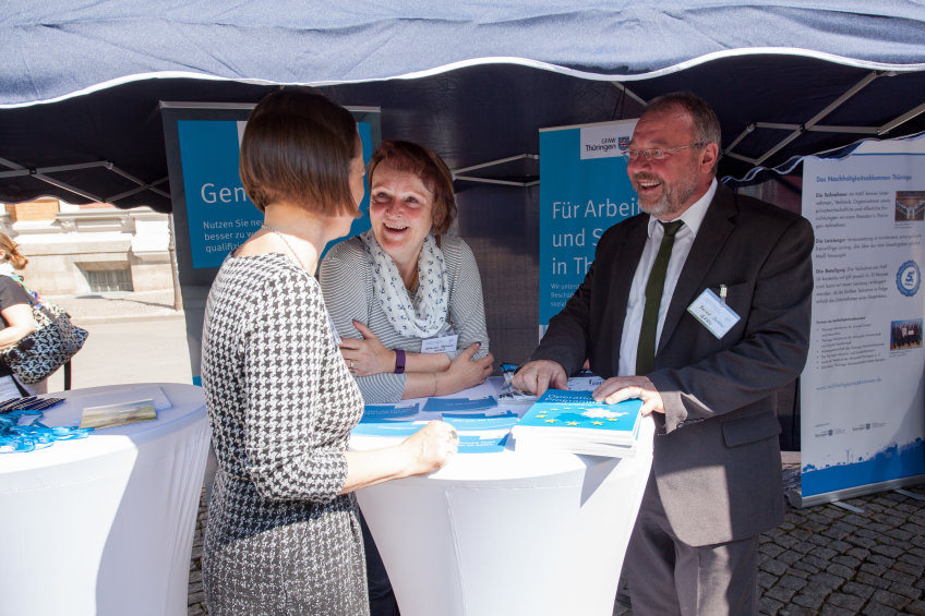 Besucher im Gespräch an einem Stehtisch
