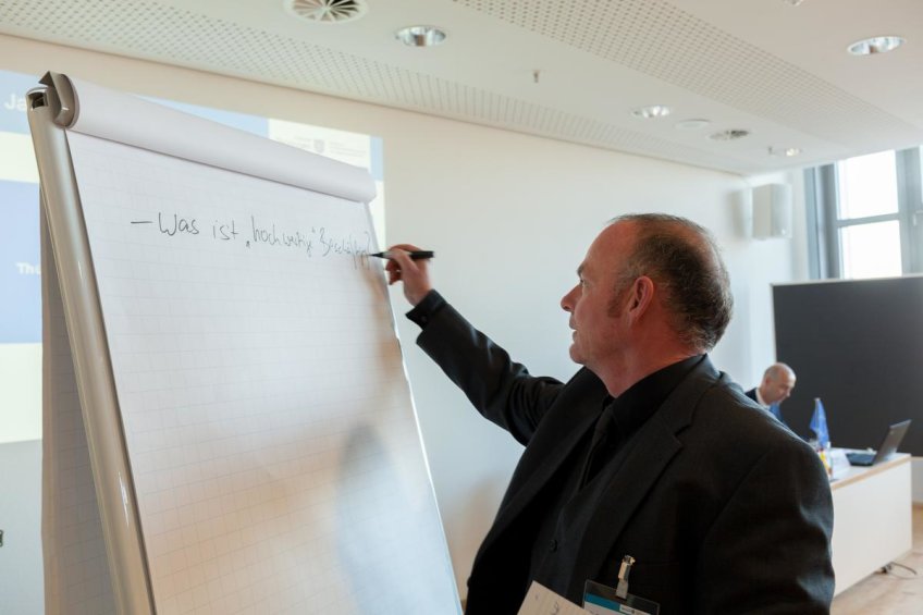Mann notiert auf Flipchart:"Was ist hochwertige Beschäftigung?"