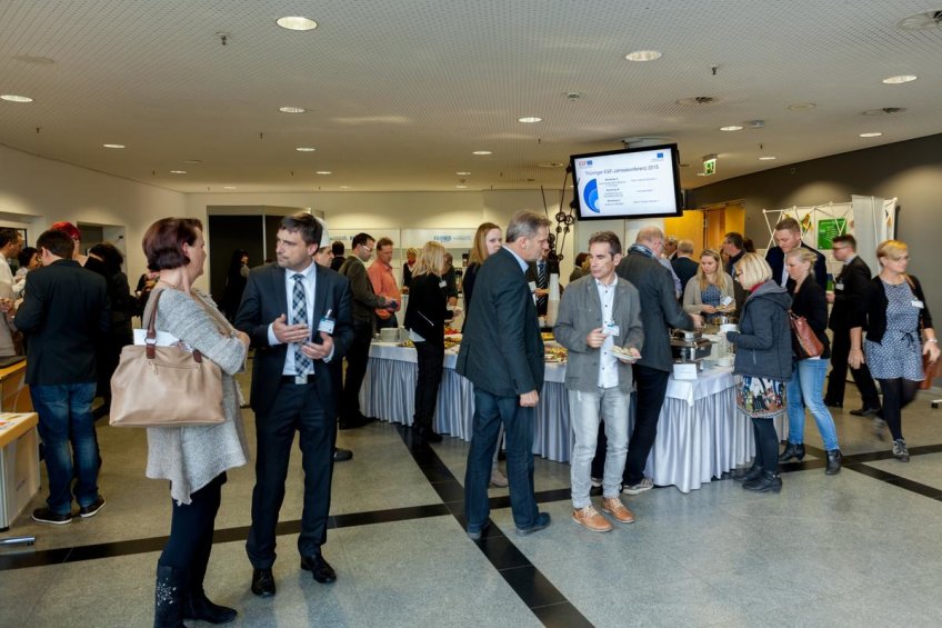 Teilnehmerinnen und Teilnehmer im Gespräch am Buffet