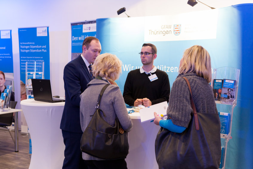 Veranstaltungsteilnehmerinnen und -teilnehmer im Gespräch vor den Projektwänden