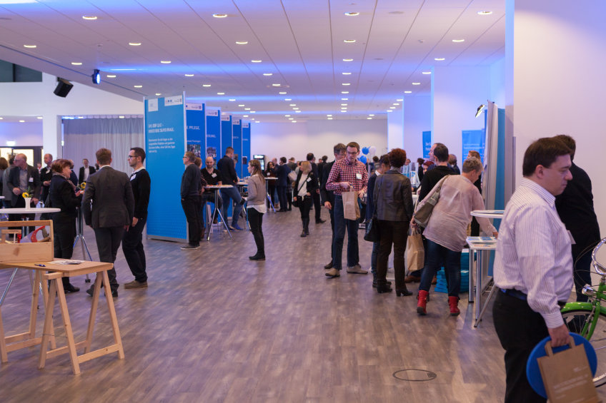 Blick ins Foyer mit vielen Teilnehmern und Teilnehmerinnen im Gespräch